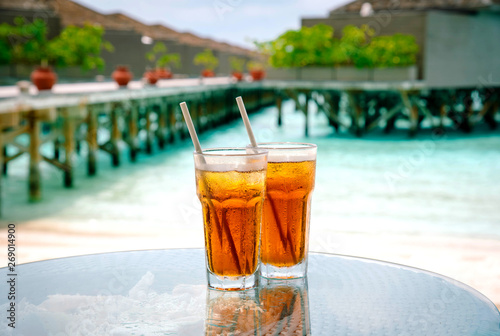 Iced tea against tropical Overwater Bungalow Resort.