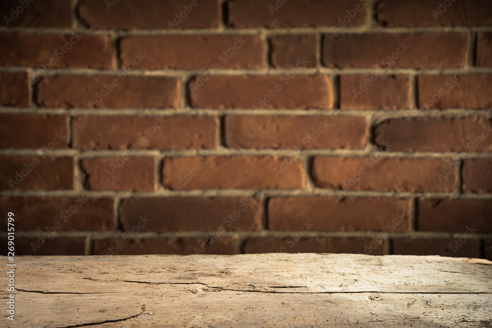 Old wooden table with brick background dark