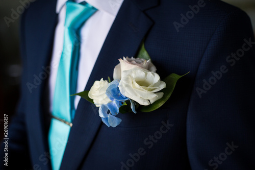 Businessman in blue suit tying the necktie. Smart casual outfit. Man getting ready for work.The morning of the groom