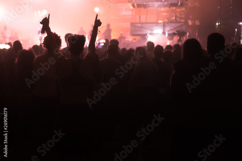 people at a concert with their hands in the air dancing and singing 