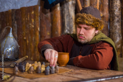 Portrait of man in russian ethnic suit playing chess