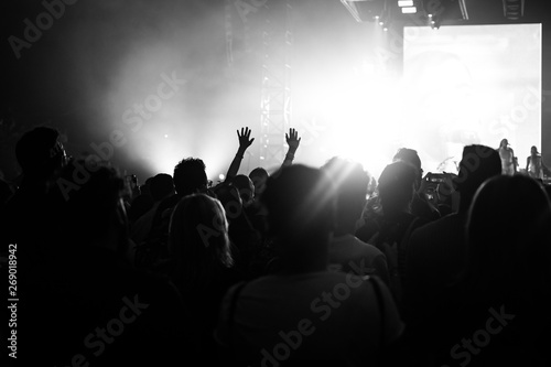 people at a concert with their hands in the air dancing and singing 