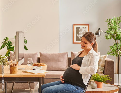 Pregnant woman is working hard at the office or home style.
