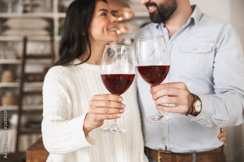 Portrait of happy european couple drinking wine from glasses while having romantic dinner at home Portrait of happy european couple drinking wine from glasses while having romantic dinner at home