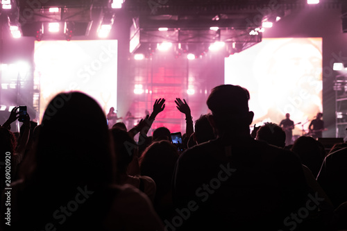 people at a concert with their hands in the air dancing and singing 