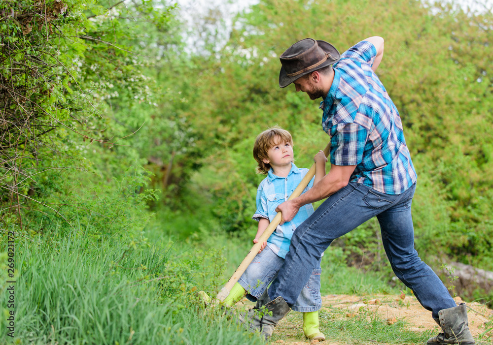 Little boy and father with shovel looking for treasures. Happy childhood. Adventure hunting for treasures. Little helper in garden. Cute child in nature having fun with cowboy dad. Find treasures