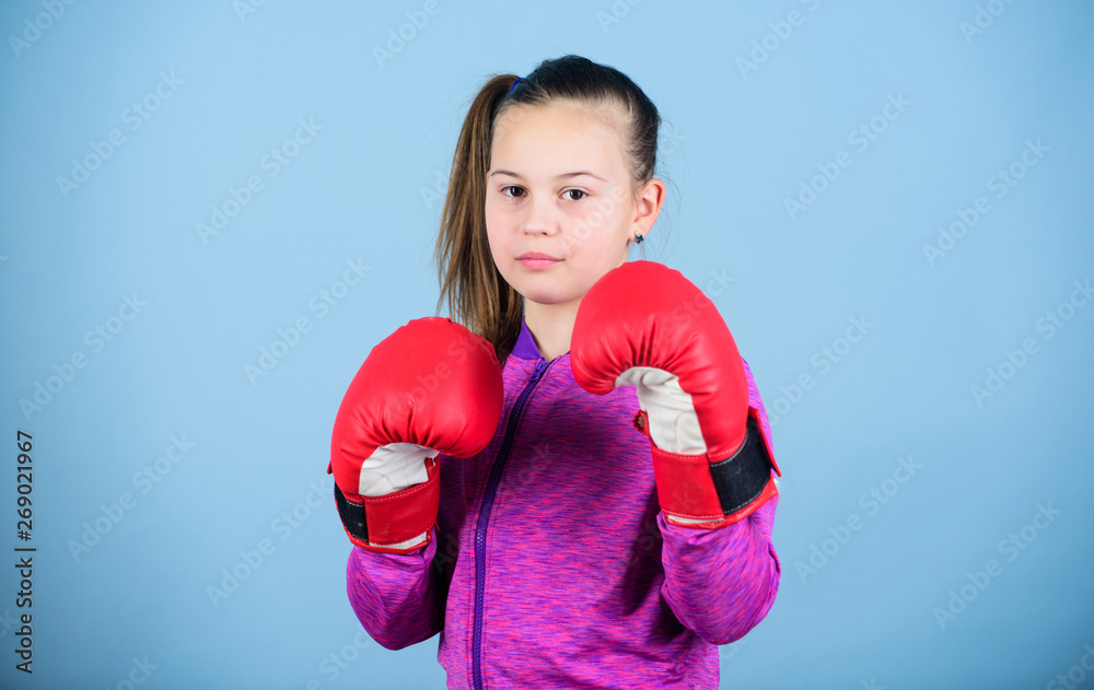 Girl cute boxer on blue background. With great power comes great responsibility. Contrary to stereotype. Boxer child in boxing gloves. Female boxer. Sport upbringing. Boxing provide strict discipline Girl cute boxer on blue background. With great power comes great responsibility. Contrary to stereotype. Boxer child in boxing gloves. Female boxer. Sport upbringing. Boxing provide strict discipline