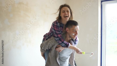 Funny video, the couple is fooling around in a new house against the background of the window. Happy couple husband and wife making repairs to their home