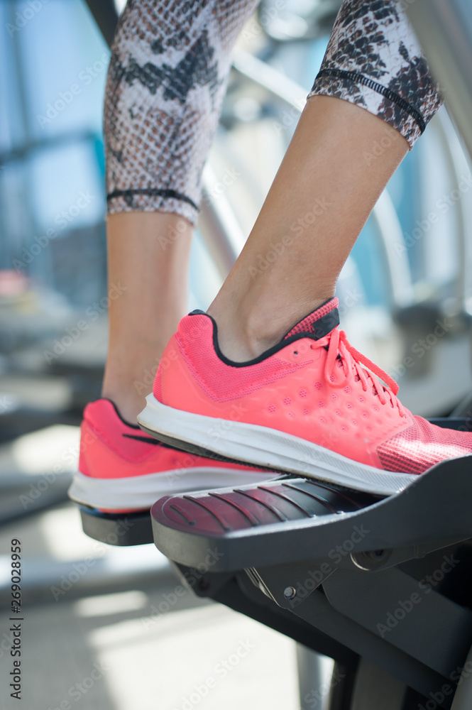 Closeup of woman using stepper and training in fitness center