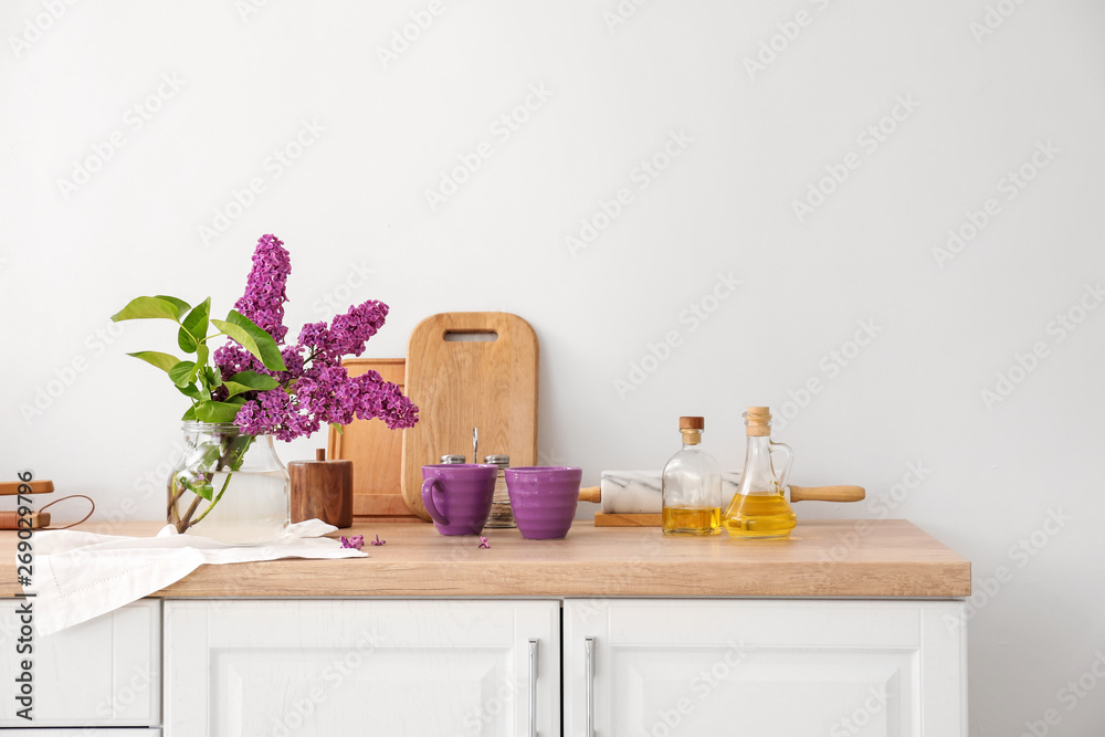 Beautiful lilac flowers on counter in kitchen