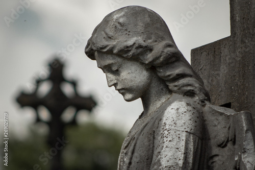 Graveyard sculpture of a young girl, her head bowed in sorrow, expresses the poignancy felt by the bereaved