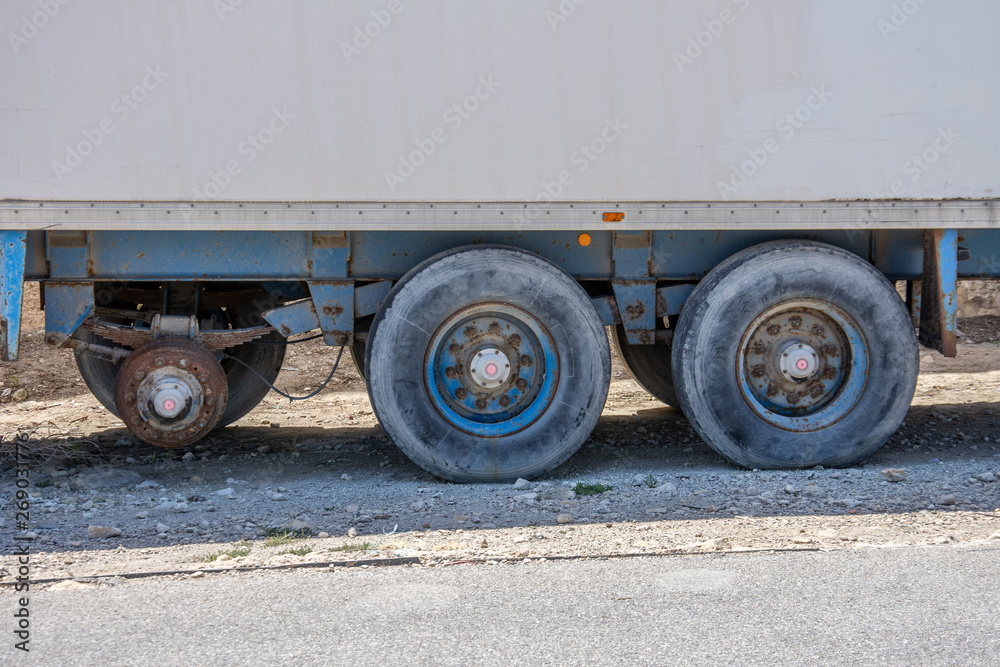 Cargo container trailer without one wheel breaking in the parking lot. Cargo container trailer without one wheel breaking in the parking lot.