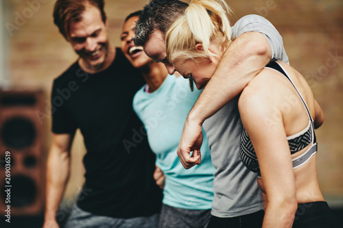 Diverse group of fit friends laughing together at the gym