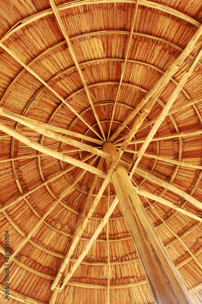 Look up detail view of straw umbrella/parasol on the beach.