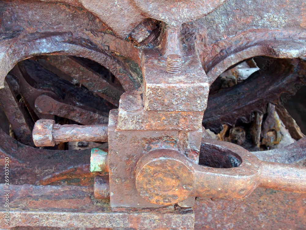 close up of brown rusted threaded bolts and nuts on old corroded machinery