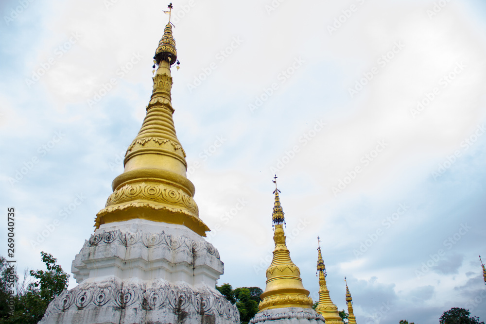 Fototapeta premium Many golden pagodas on the courtyard of temple in northern thailand, with blue sky background.