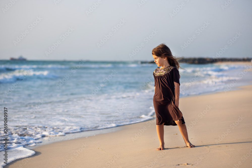Young girl running along the beach in Dubai Young girl running along the beach in Dubai