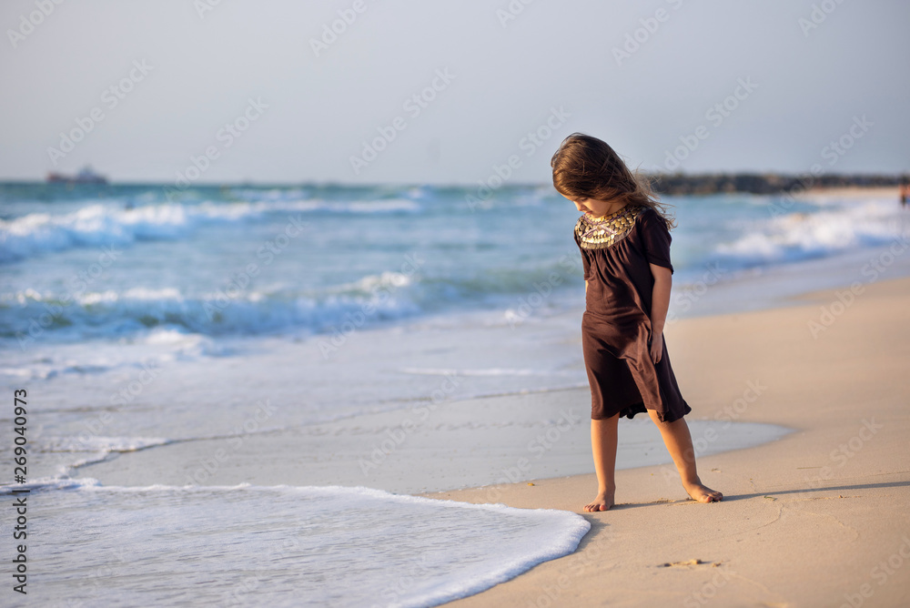 Young girl running along the beach in Dubai
