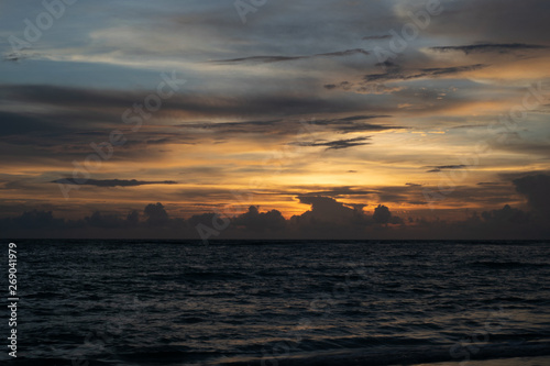 sunset Overcast sky, orange light, calm sea waves © Paveena