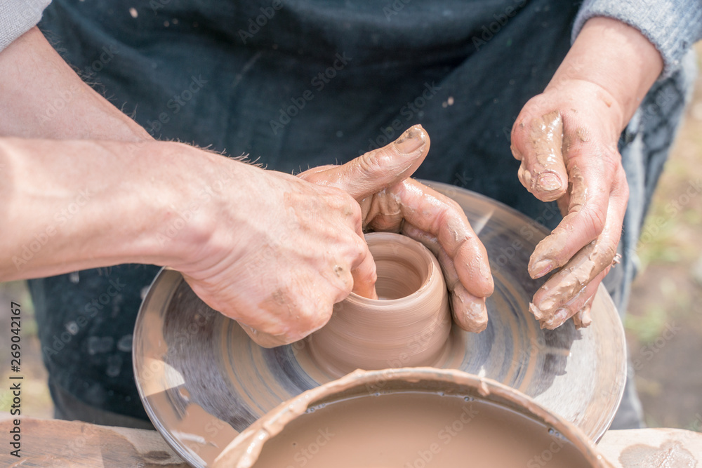 Master teaching pottery. Working with clay. Master ceramist teaches student. Craftsman hands making pottery bowl. Master teaching pottery. Working with clay. Master ceramist teaches student. Craftsman hands making pottery bowl.