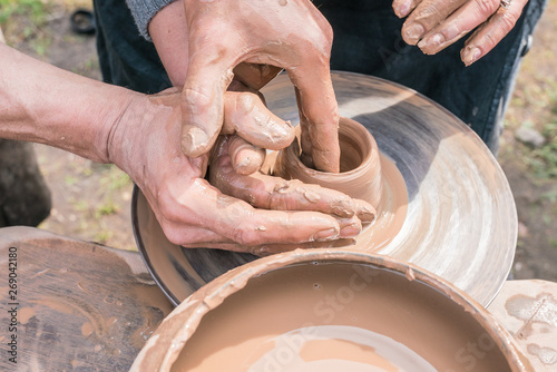 Master teaching  pottery. Working with clay. Master ceramist teaches student. Craftsman hands making pottery bowl. 
