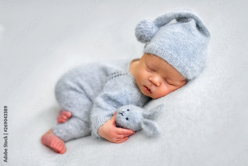 Sleeping newborn boy in the first days of life on white background - obrazy, fototapety, plakaty 