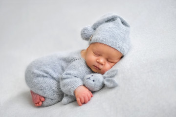 Sleeping newborn boy in the first days of life on white background