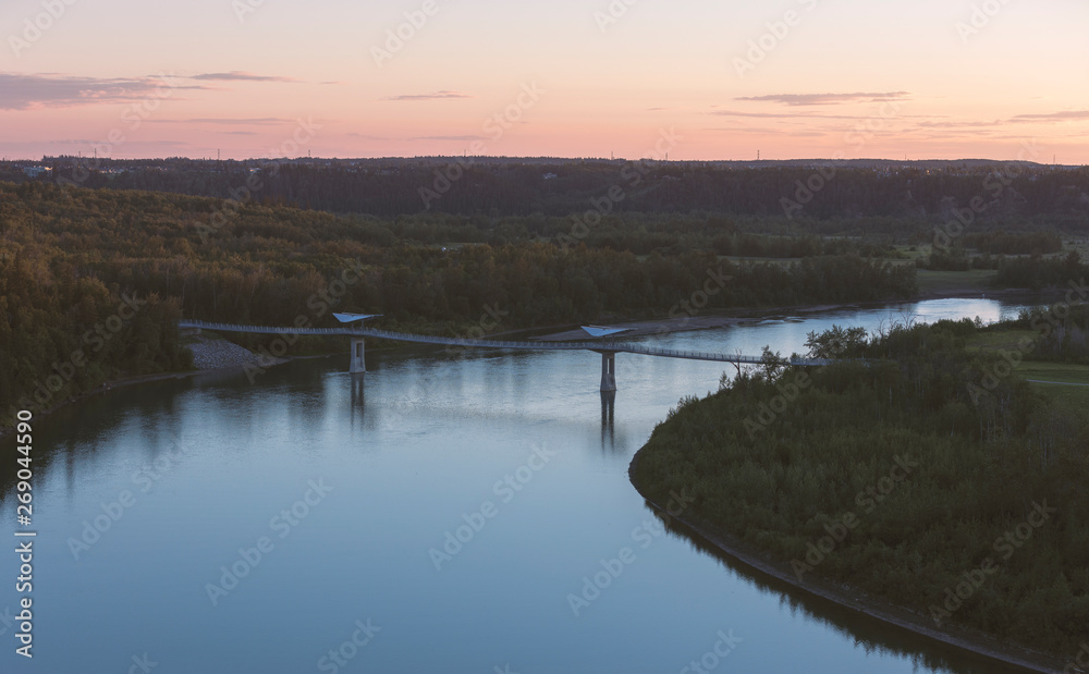 Beautiful sunset over the North Saskatchewan River and Terwillegar Park Footbridge in Edmonton, Alberta, Canada