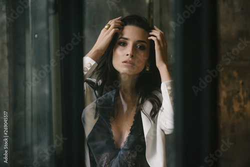 Young brunette woman posing in a suit by the window © Alexander