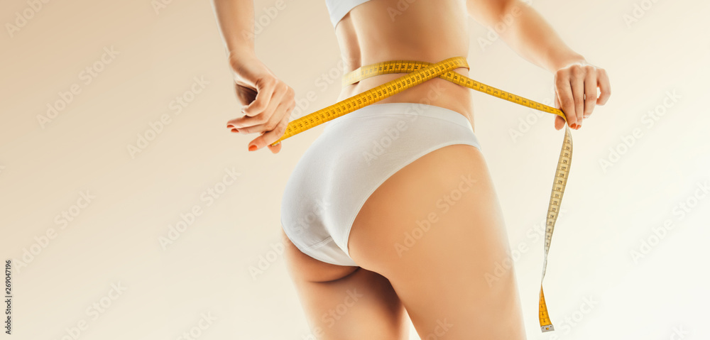 slimming woman in panties with yellow measure