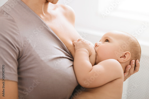 Mother breast feeding and hugging her baby