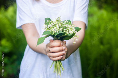 Woman holding a bouquet of lilly of valley flowers