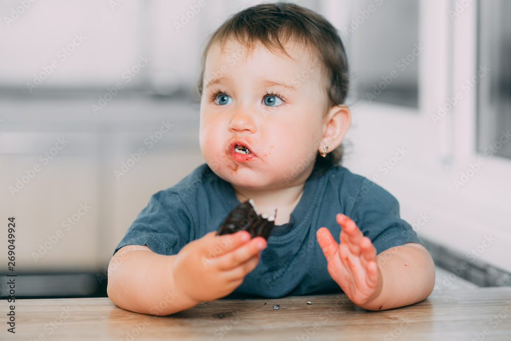 Little girl in the kitchen eating marshmallows in chocolate or chocolate chip cookies Little girl in the kitchen eating marshmallows in chocolate or chocolate chip cookies