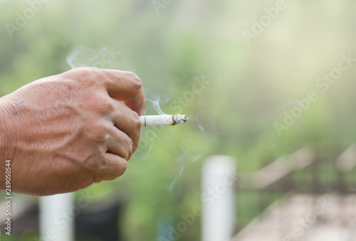 Hand of young man holding cigarette