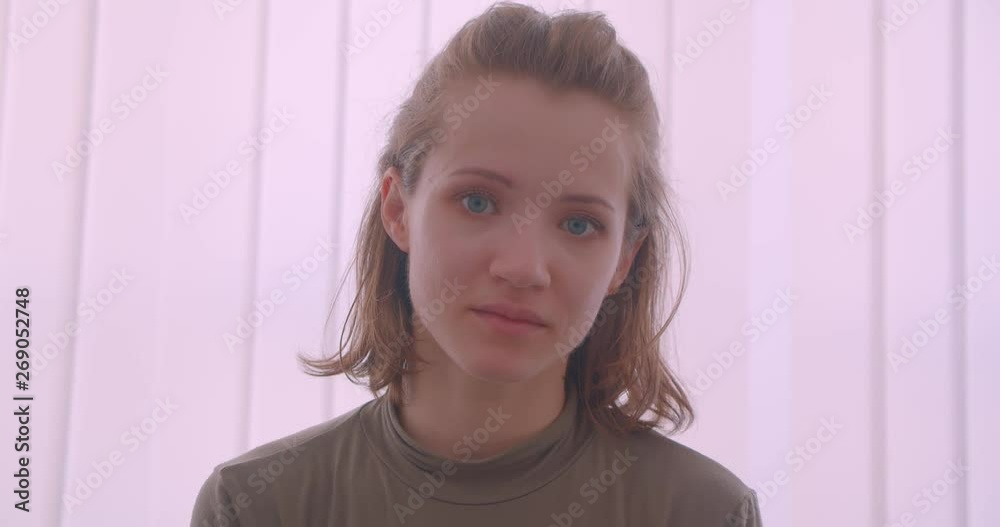 Close-up portrait of caucasian professional ballerina smiles calmly into camera in light studio. Close-up portrait of caucasian professional ballerina smiles calmly into camera in light studio.