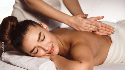 Woman Enjoying Relaxing Back Massage In Spa Centre