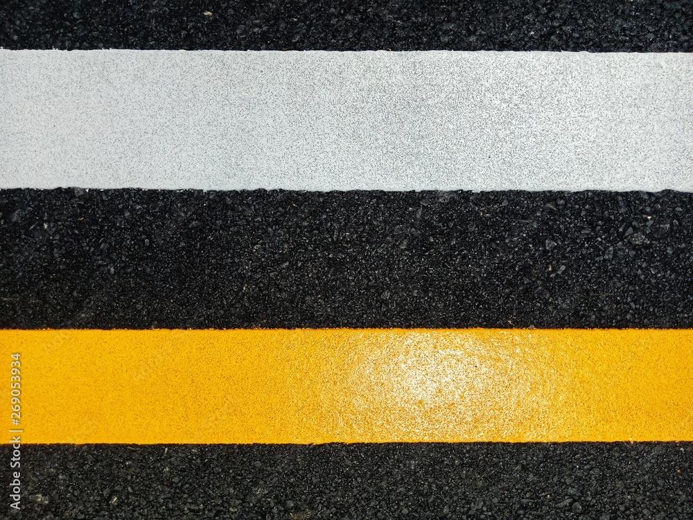 Road traffic paint Yellow on the asphalt surface Road traffic paint Yellow on the asphalt surface