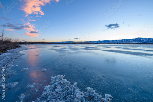 Winter Lake - Light clouds reflecting on blue icy cold winter lake at sunset. Chatfield State Park, Denver-Littleton, Colorado, USA.