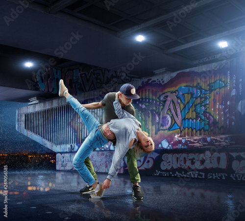 Hip Hop Dancers. Beautiful couple dancing at night on the background of graffiti wall