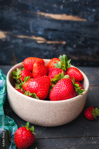 Close-up of fresh strawberries in a bowl on wooden background