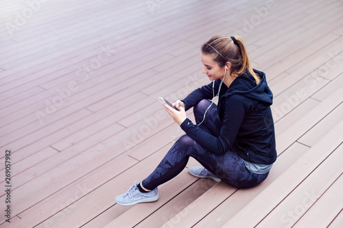 Young woman using cellphone and sittinng on stairs photo