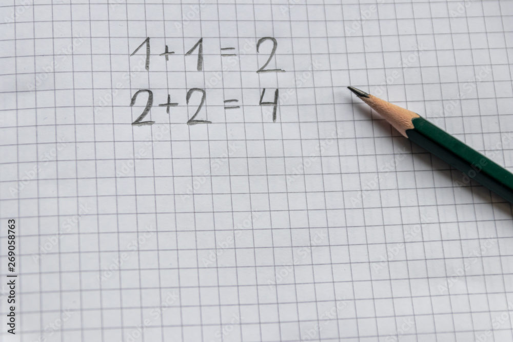 Einfache Rechenaufgabe für Grundschüler zum Schulanfang auf einem karierten Blatt Papier mit Bleistift Einfache Rechenaufgabe für Grundschüler zum Schulanfang auf einem karierten Blatt Papier mit Bleistift