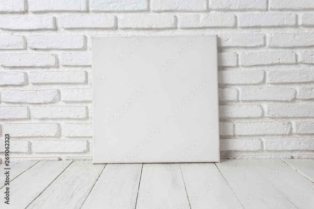Empty white canvas frame on a wooden table Empty white canvas frame on a wooden table