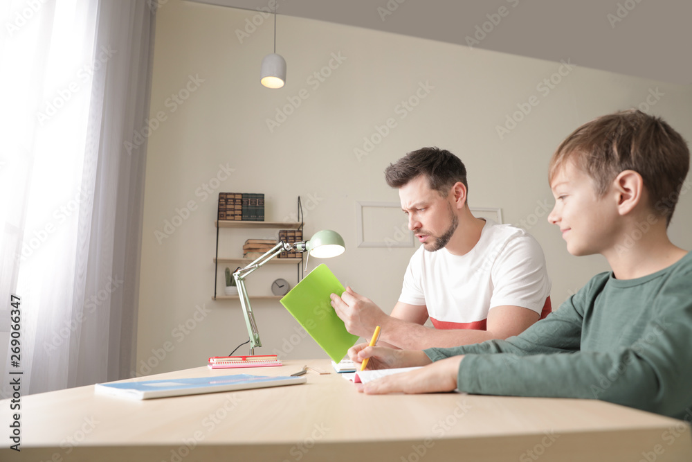 Dad struggling to help his son with school assignment at home Dad struggling to help his son with school assignment at home