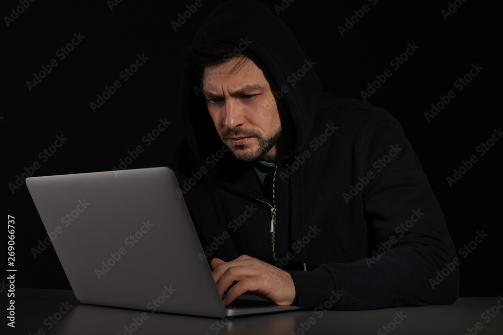 Man using laptop in darkness. Criminal activity Man using laptop in darkness. Criminal activity