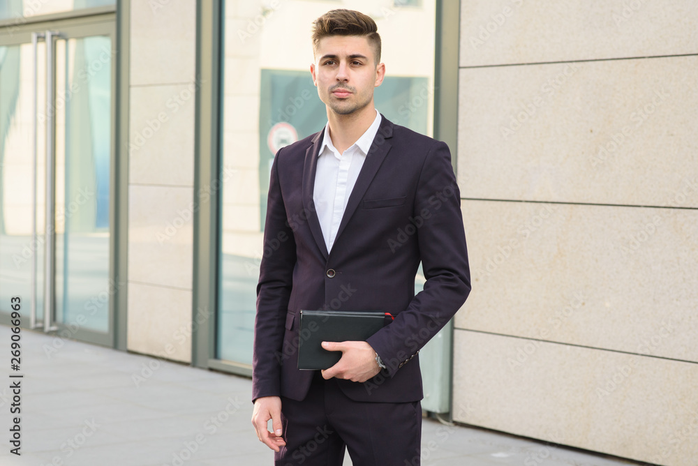 Portrait of successful businessman open in modern city near business center Portrait of successful businessman open in modern city near business center