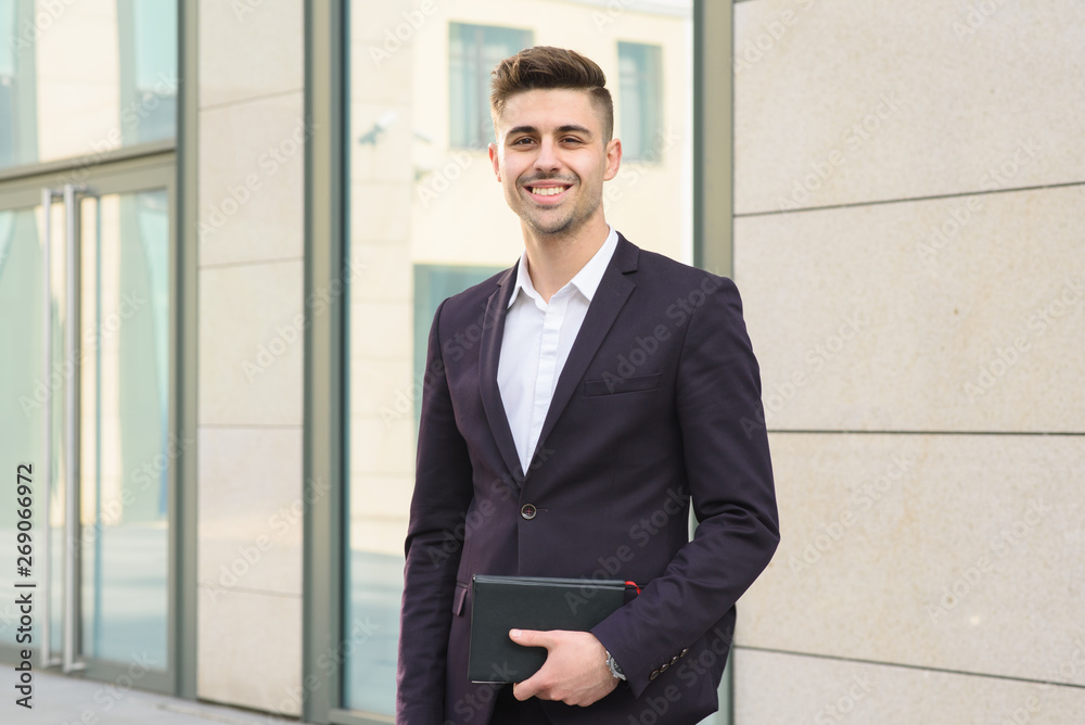 Portrait of successful businessman open in modern city near business center Portrait of successful businessman open in modern city near business center