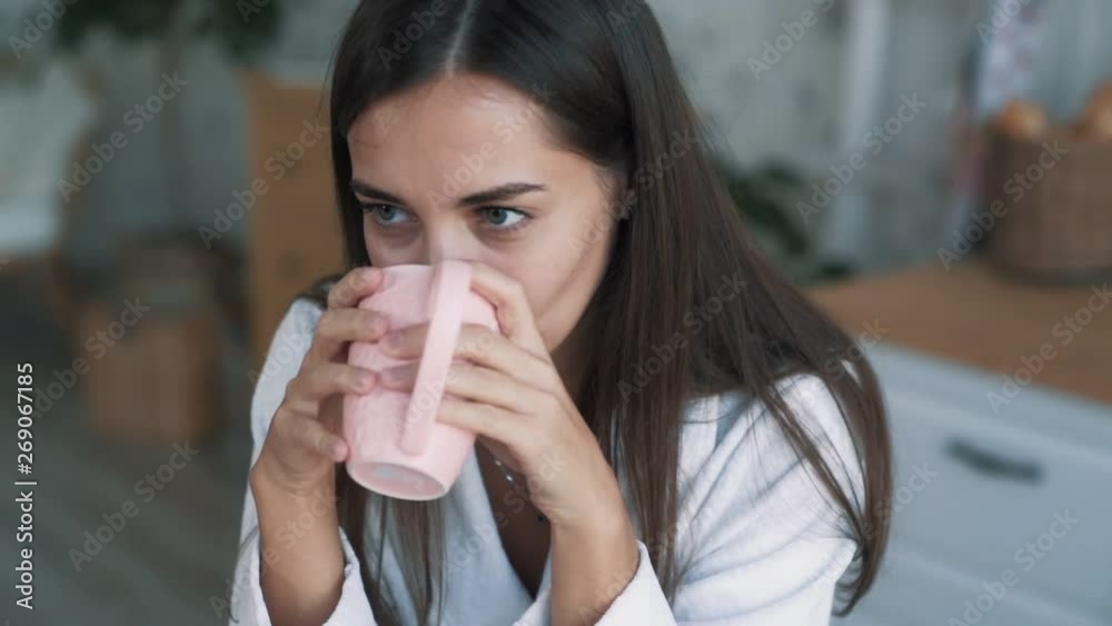 Close up portrait of girl drinks tea or coffee and sniffs hot beverage, slow motion Close up portrait of girl drinks tea or coffee and sniffs hot beverage, slow motion
