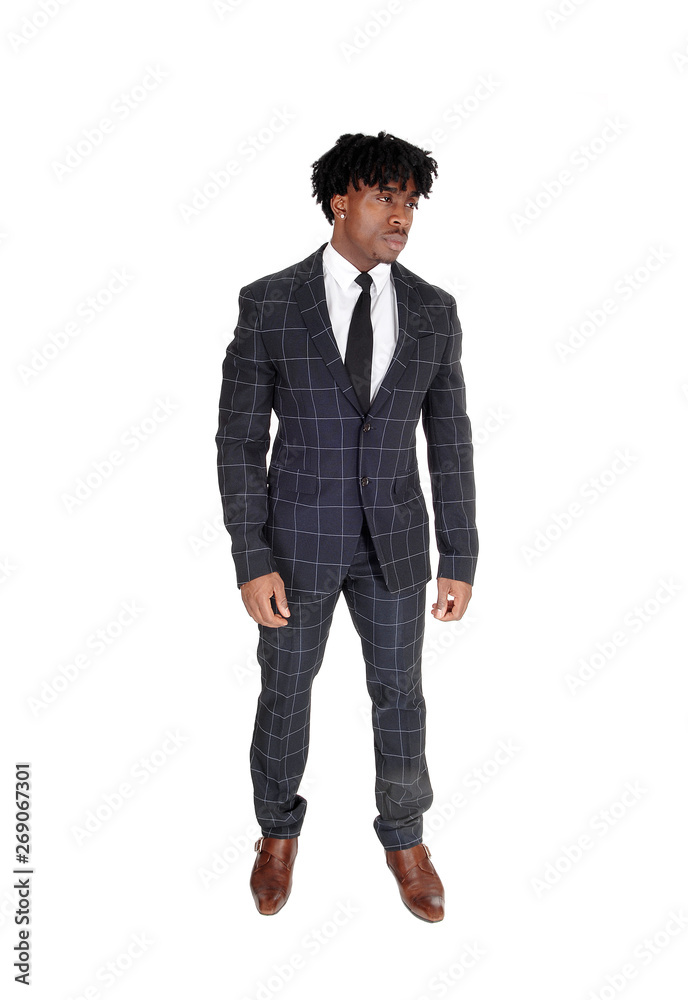 African man in a dark suit standing in the studio with fussy black hair African man in a dark suit standing in the studio with fussy black hair