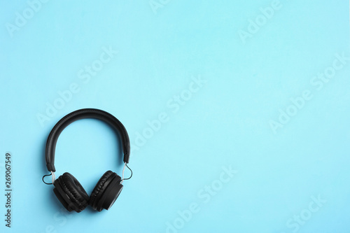 Stylish headphones on color background, top view. Space for text